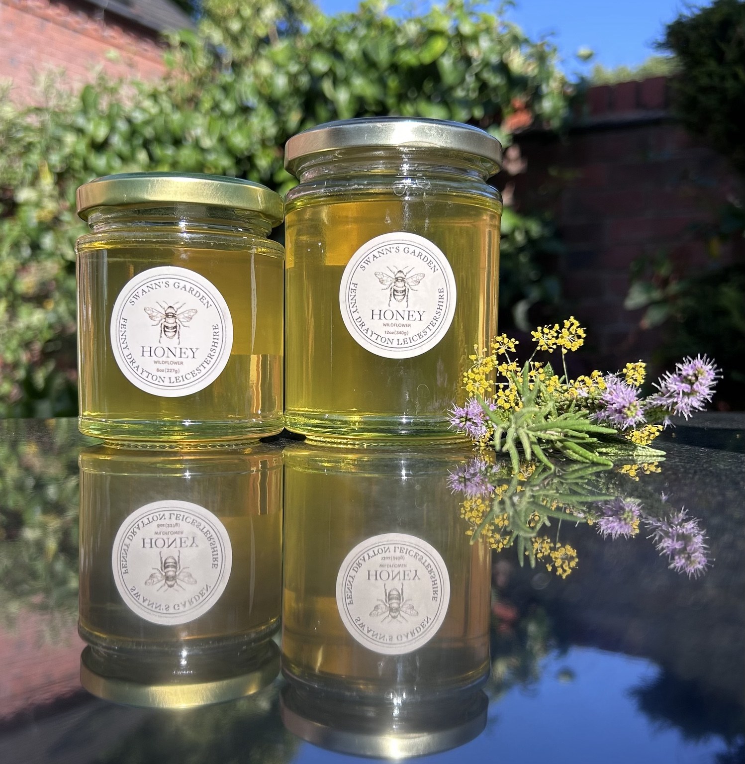 8oz and 12oz jars of Swann's Garden wildflower honey